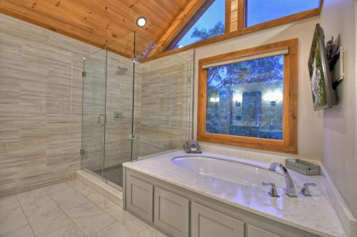 a bathroom with a tub and a shower and a window at Honey Hill Gorgeous long-range mountain views in Morganton