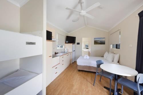 a hotel room with a bed and a table and chairs at Reflections Evans Head - Holiday Park in Evans Head