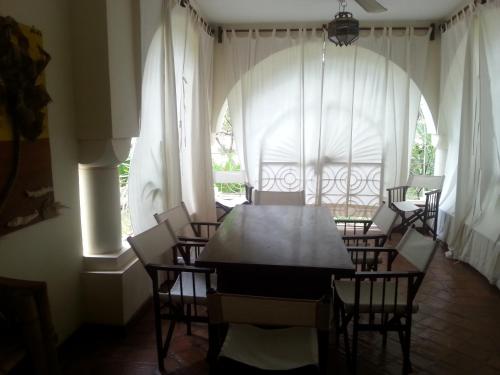 comedor con mesa, sillas y ventana en Kilimandogo Residence en Malindi