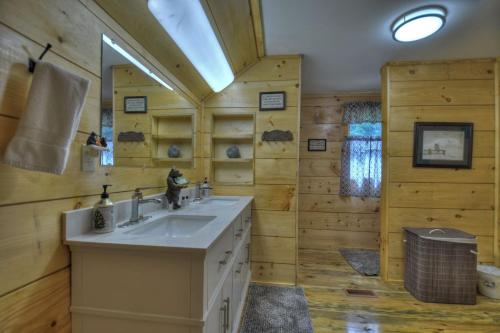 a bathroom with a sink and a mirror at Bear Naked Hideaway - Relax in the hot tub with sounds from the nearby creek in Epworth