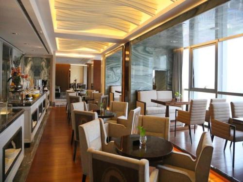 a dining room with tables and chairs and windows at Xian Jue Vu Hotel in Xi'an