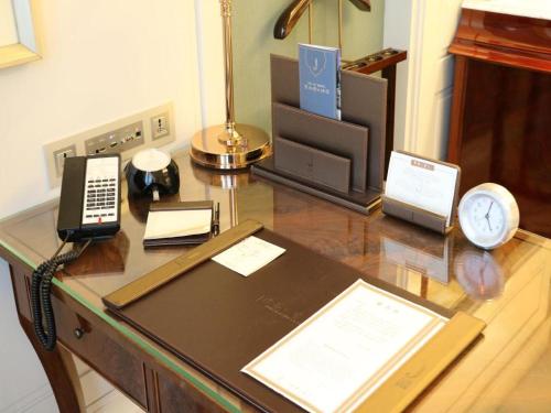 a desk with a phone and a clock on it at Xian Jue Vu Hotel in Xi'an
