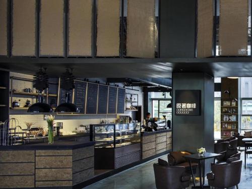 a restaurant with a counter and chairs in a room at Chongqing The Lotus Hotel in Chongqing