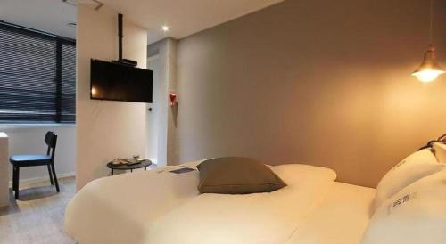a bedroom with a bed and a tv on the wall at Hotel Yam ANDONG in Andong