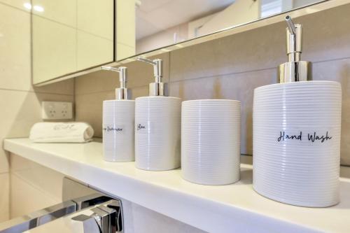 three stacks of paper towels sitting on a shelf in a bathroom at Harbour View Suite in Darwin