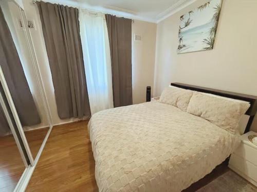 a bedroom with a bed and a large window at Entire Home in Blacktown in Blacktown