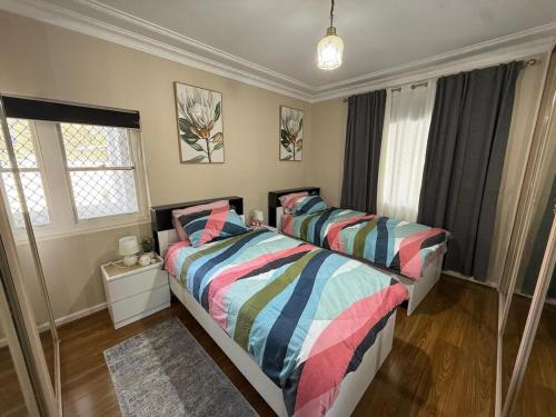 a bedroom with two beds and two windows at Entire Home in Blacktown in Blacktown