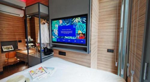 a bedroom with a flat screen tv on the wall at Hotel Soloha @ Chinatown in Singapore