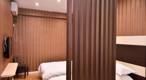 a room with two beds and a bedroom with a bed sqor at Super 8 Hotel Yiwu Binwang in Yiwu