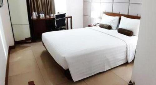 a large white bed in a hotel room at PARK HOTEL Cawang Jakarta in Jakarta