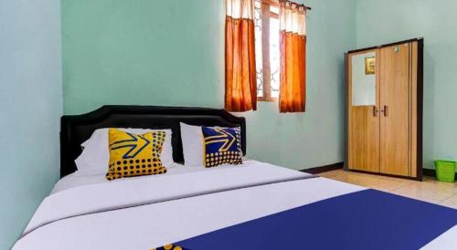 a bedroom with a large bed with two pillows at SPOT ON 91159 Kost Putrana Syariah in Bandung