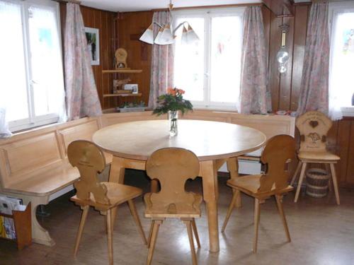 a dining room table and chairs with a table and windows at B&B Hofstetter in Schachen