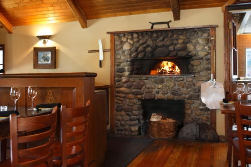 a stone fireplace in a restaurant with a bar at Buffalo Mountain Lodge in Banff