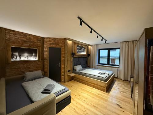 a bedroom with two beds and a brick wall at Pension U Studny in Harrachov