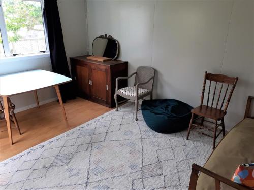 a room with two chairs and a table and a mirror at Peace and quiet in the Brooklyn hills in Wellington