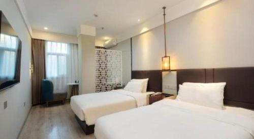 a hotel room with two beds and a television at Magnotel Shanghai Maglev Station in Shanghai