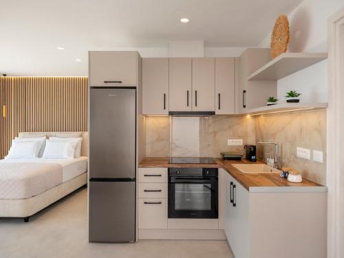 a kitchen with white cabinets and a bed in a room at Salty Dreams in Piso Livadi