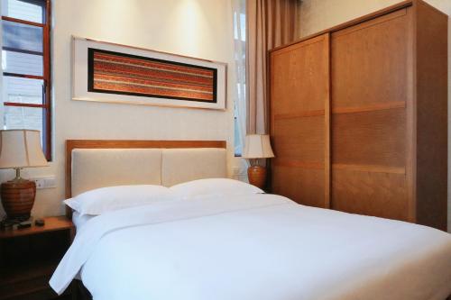 a bedroom with a large white bed with a wooden headboard at Avatar Valley Villas in Zhangjiajie