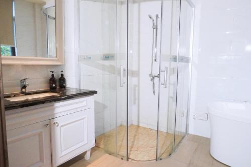 a shower with a glass door in a bathroom at Avatar Valley Villas in Zhangjiajie