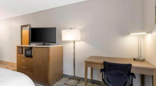 a bedroom with a desk with a bed and a television at Best Western Galt Inn in Galt