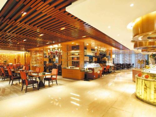 a dining room with tables and chairs in a restaurant at Changsha Huatian Hotel in Changsha