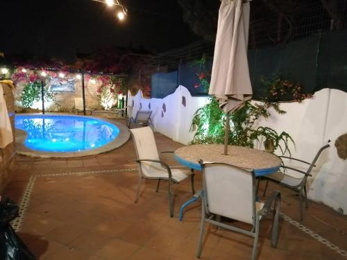 a patio with a table and chairs and a pool at Charming Villa in Punta Umbría with Private Pool in Punta Umbría