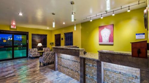 a lobby with a bar with yellow walls at Best Western Rama Inn in Ephrata