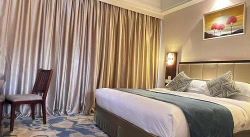 a hotel room with a bed and a chair at Yangshuo Greenlotus Hotel in Yangshuo