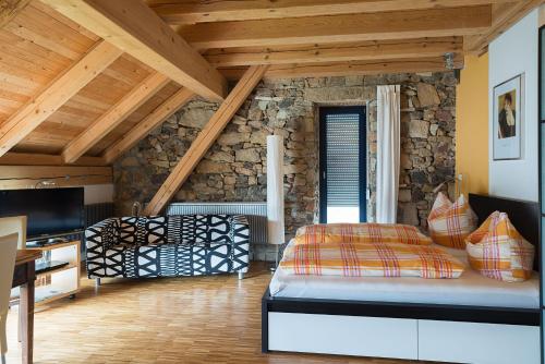 a bedroom with a bed and a stone wall at Alte Scheune Rietzschelhof in Müglitztal