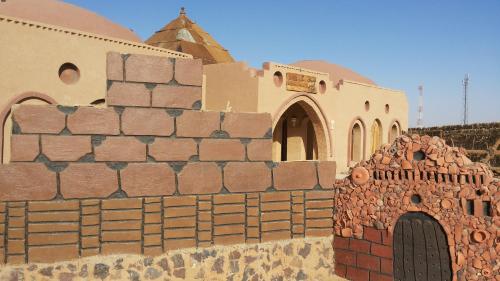 a brick wall in front of a building at Qasr El Bagawat Hotel in ‘Ezbet Halfa
