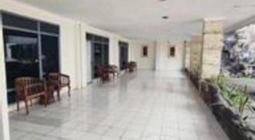 a large room with a hallway with tables and chairs at Alexander Hotel Tegal in Tegal