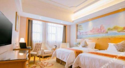 a hotel room with two beds and a flat screen tv at Vienna International Shenzhen Tianan Digital City in Shenzhen