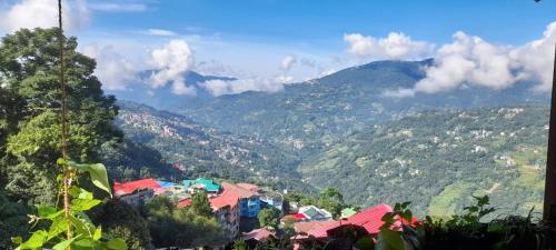 a view of a town in a valley with mountains at Bungkhim Urban Garden Homestay in Gangtok