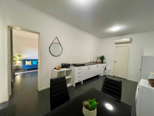 cocina blanca con mesa y barra en Private unit in Whitehaven Crescent, en Cannonvale
