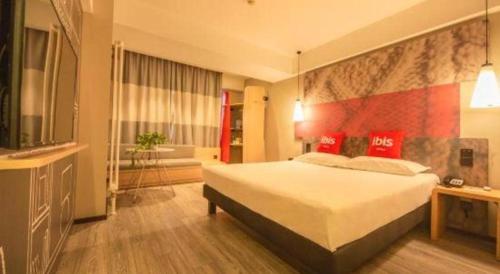 a bedroom with a large bed and a bathroom at ibis Shenyang north station in Shenyang