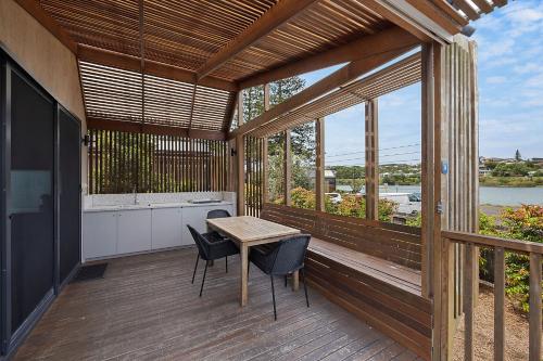 a patio with a table and chairs on a deck at Reflections Evans Head - Holiday Park in Evans Head