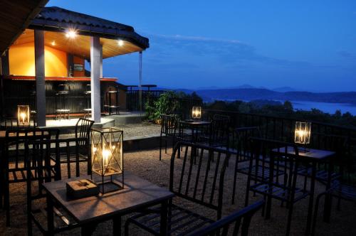 a restaurant with tables and chairs on a balcony at night at Lavendish Lake Giritale in Polonnaruwa