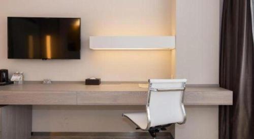 a desk in a hotel room with a chair at Jinjiang Metropolo Shanghai Xujiahui Nanhuating Hotel in Shanghai
