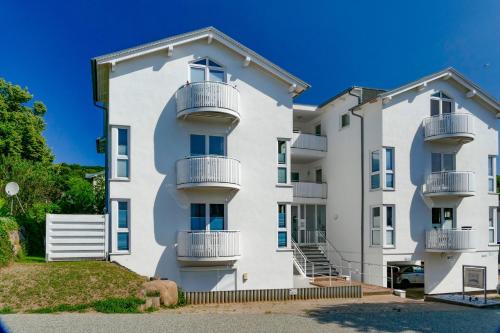 a white apartment building with balconies at Villa Monika Steuerbord 5 in Sassnitz