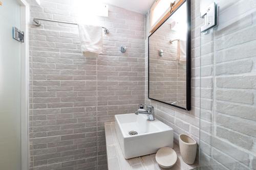 Un baño blanco con lavabo y espejo. en Purity Studio, en Anemómylos