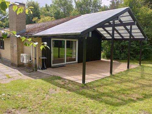 a screened in deck with a solar roof at Rosenby Hytten in Dronninglund