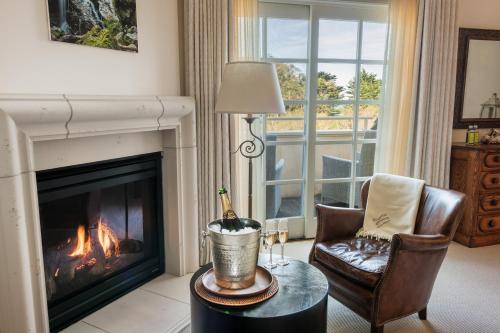 a living room with a fireplace and a bottle of champagne at Seal Cove Inn in Half Moon Bay