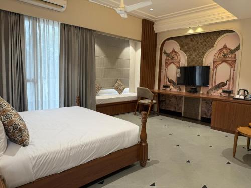 una camera da letto con un letto, una scrivania e una televisione di The Luxury Tiger at Lake Pichola a Udaipur