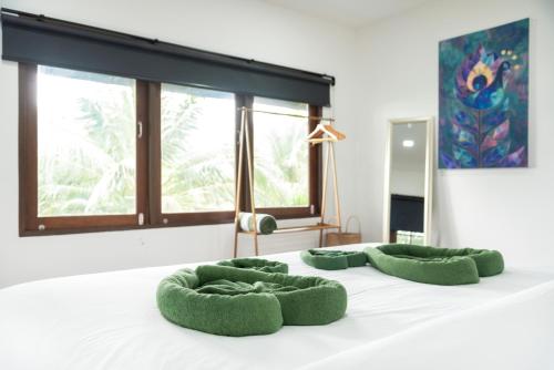 un letto con quattro cuscini verdi di Fisherman's Village Bophut Private Pool Villa a Nathon Bay