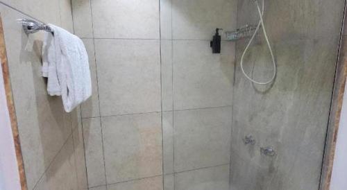 a bathroom with a shower with a glass door at Merrils Deluxe in Negril