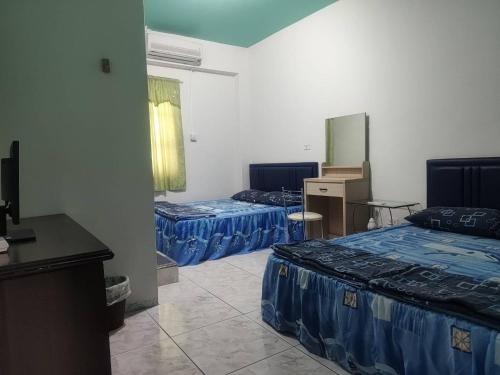 a hotel room with two beds and a desk at 藍嶼休閒民宿 in Lanyu