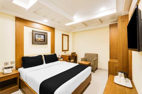 a hotel room with a bed and a television at Palette Alandur Near Chennai Airport in Chennai