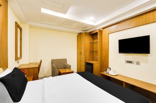a hotel room with a bed and a flat screen tv at Palette Alandur Near Chennai Airport in Chennai