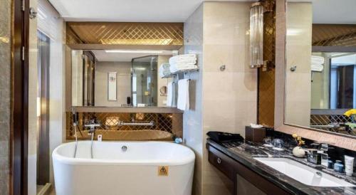 a bathroom with a large tub and a sink at Chengdu Rising Butterfly Hotel in Chengdu