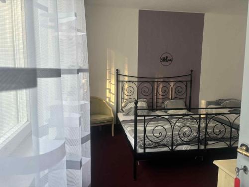 a bedroom with a bed with a wrought iron frame at Limonádé Vendégház in Balatonberény